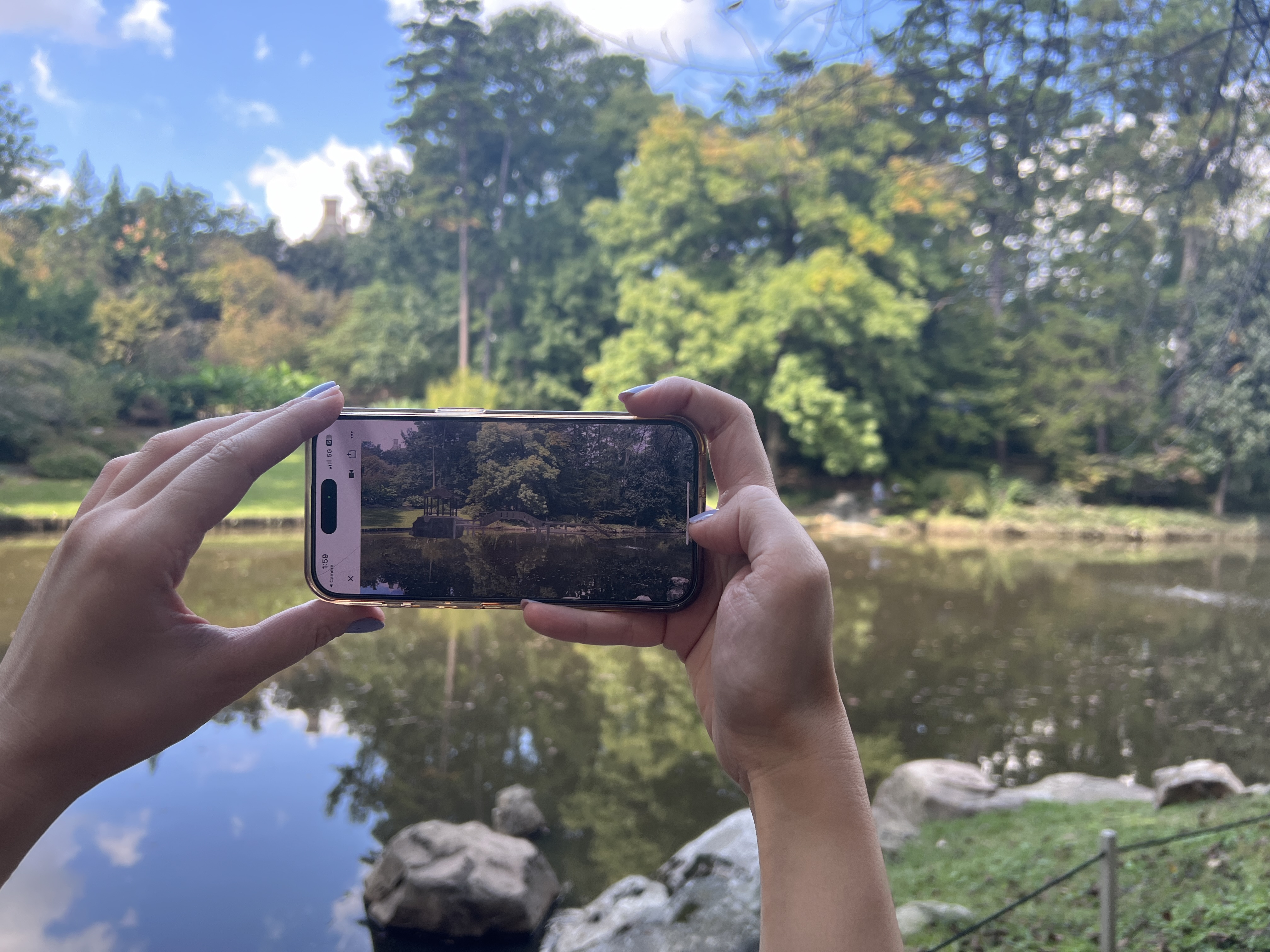 A phone presenting the Parallel Bridges augmented-reality experience at Duke Gardens